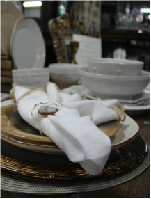 Close up of white and gold china plate with napkin placed over.