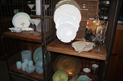 Crop photo of white china on a shelf with other china assortment around it.